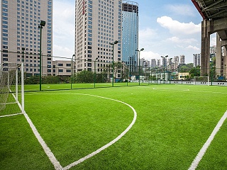 如何避免人造草足球场在施工过程中出现凹凸不平的现象？